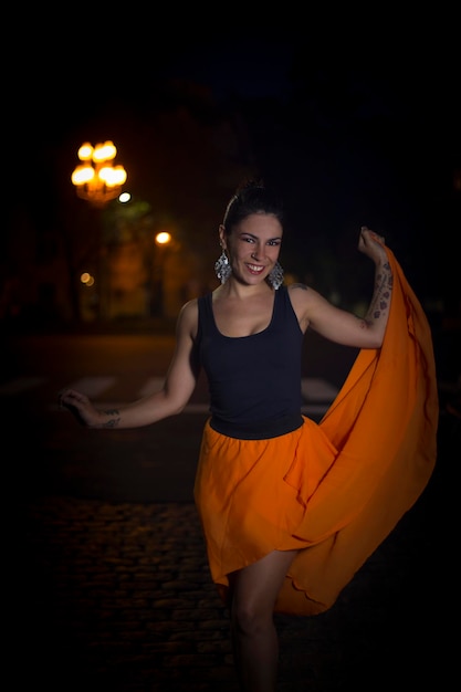 Foto retrato de una joven modelo de moda sonriente por la noche