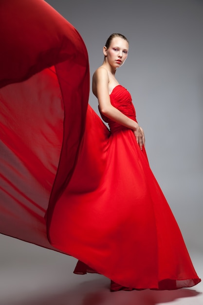 Retrato, de, joven, modelo, posar, en, vestido rojo, con, vuelo, skirt., Tiro del estudio