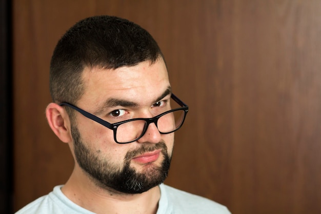 Retrato de joven moderno inteligente de pelo negro barbudo guapo