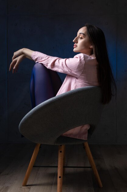 Retrato de una joven morena con cabello largo en el estudio Foto dramática en colores oscuros