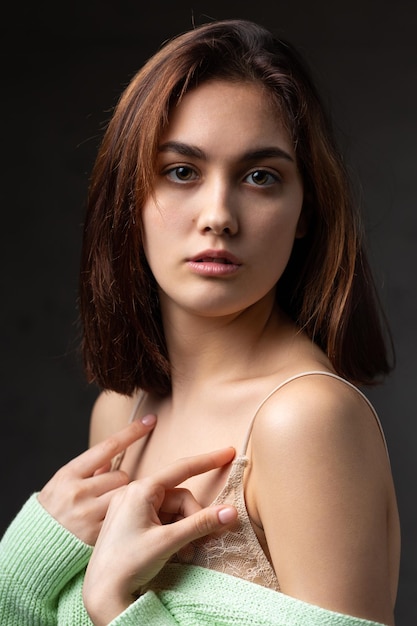 Retrato de una joven morena con cabello largo en el estudio Foto dramática en colores oscuros