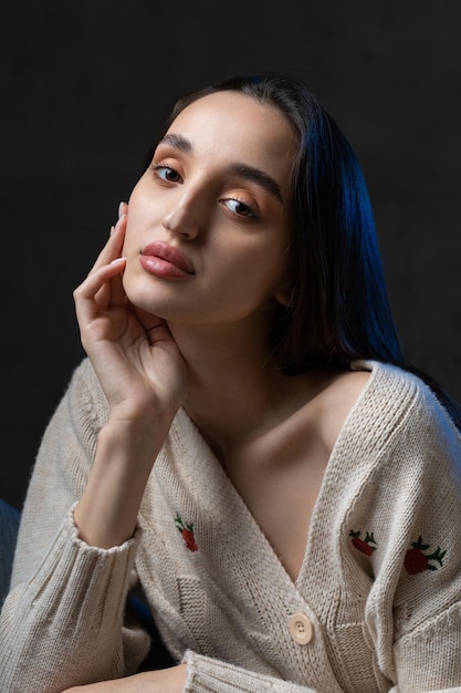 Retrato de una joven morena con cabello largo en el estudio Foto dramática en colores oscuros