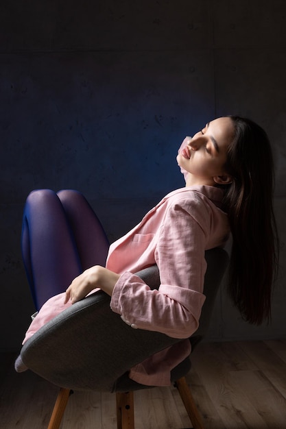 Retrato de una joven morena con cabello largo en el estudio Foto dramática en colores oscuros