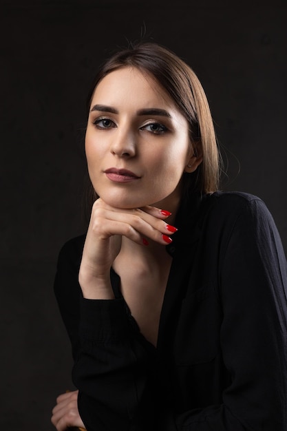 Retrato de una joven morena con cabello largo en el estudio Foto dramática en colores oscuros