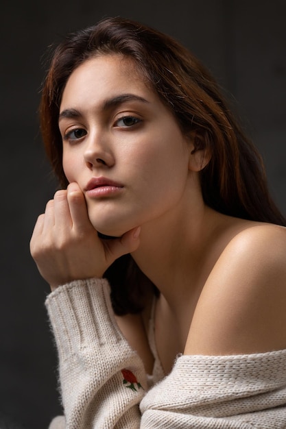 Retrato de una joven morena con cabello largo en el estudio Foto dramática en colores oscuros