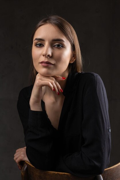 Foto retrato de una joven morena con cabello largo en el estudio foto dramática en colores oscuros