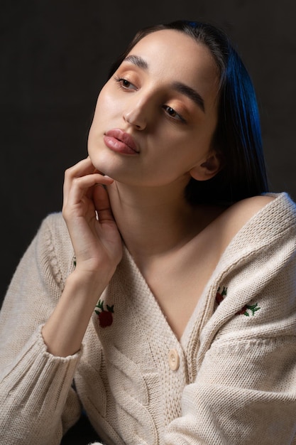 Retrato de una joven morena con cabello largo en el estudio Foto dramática en colores oscuros