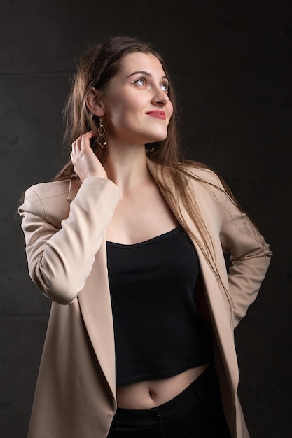 Retrato de una joven morena con cabello largo en el estudio Foto dramática en colores oscuros