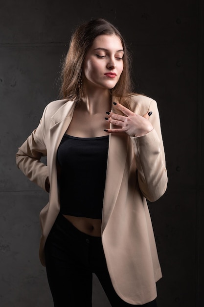 Retrato de una joven morena con cabello largo en el estudio Foto dramática en colores oscuros