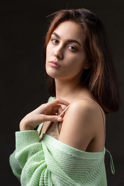 Retrato de una joven morena con cabello largo en el estudio Foto dramática en colores oscuros