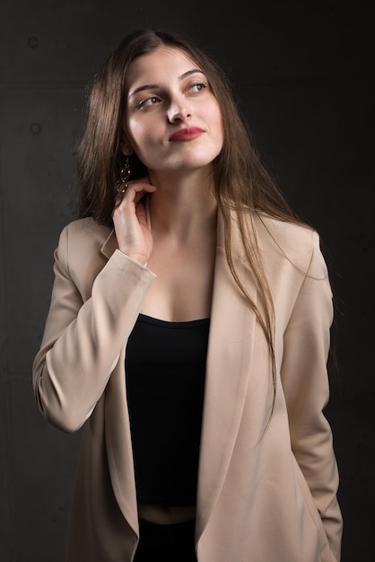 Retrato de una joven morena con cabello largo en el estudio Foto dramática en colores oscuros