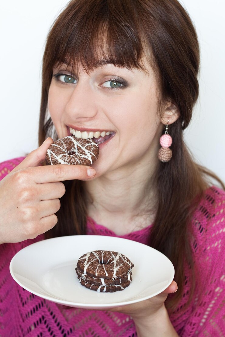 Foto retrato de una joven morena hermosa que disfruta de deliciosas galletas con trocitos de chocolate