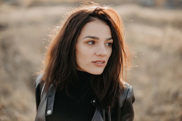 Retrato de una joven morena de moda en una chaqueta de cuero