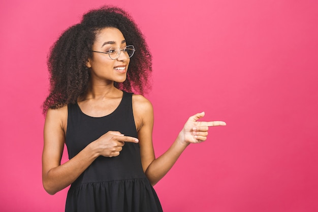 Retrato de una joven mujer afroamericana feliz apuntando