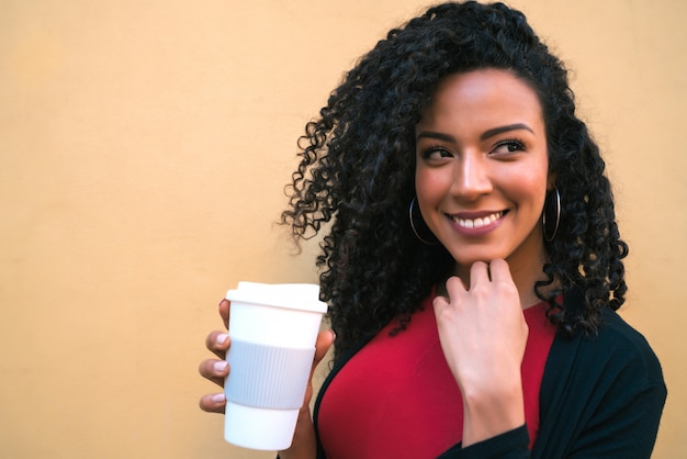 Retrato de joven mujer afroamericana tomando café