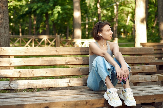 Retrato de una joven mujer americana escuchando música en el teléfono