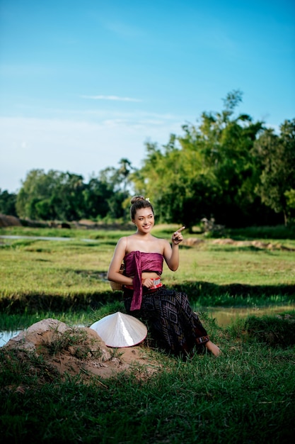 Retrato joven mujer asiática en hermosas ropas tradicionales tailandesas en el campo de arroz