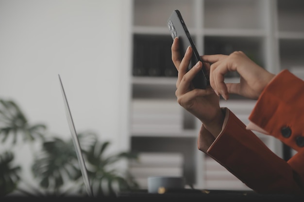 Retrato de una joven mujer asiática con la mano freelance está trabajando en su trabajo en una tableta de computadora en una oficina moderna haciendo análisis de contabilidad informe de inversión inmobiliaria datos concepto de sistemas financieros e impositivos