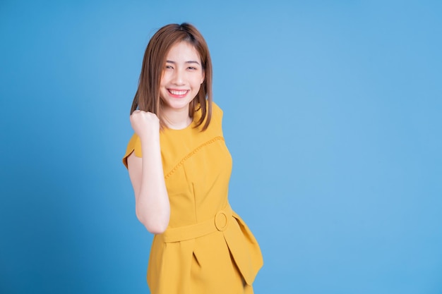 retrato, de, joven, mujer asiática, posar, en, fondo azul