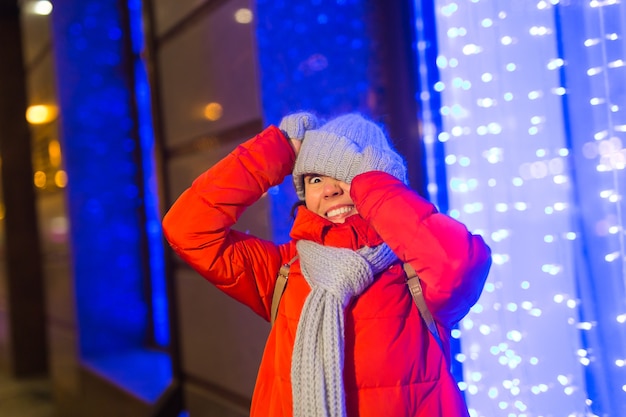 Retrato de joven mujer atractiva divertida sobre fondo de Navidad cubierto de nieve. Concepto de temporada y vacaciones de invierno.