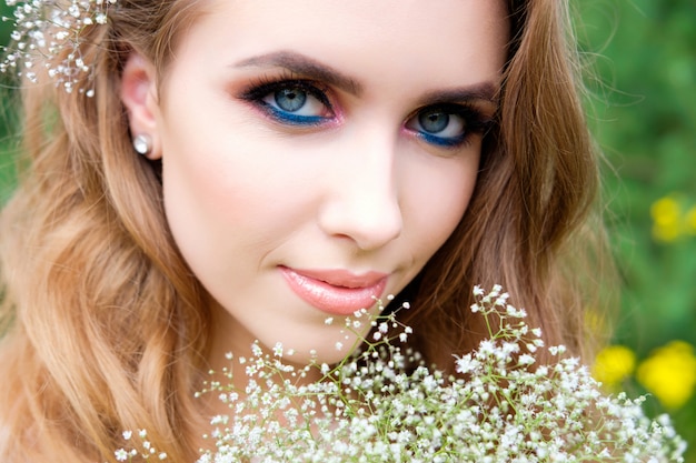 Retrato de joven mujer bonita, al aire libre, maquillaje y peinado