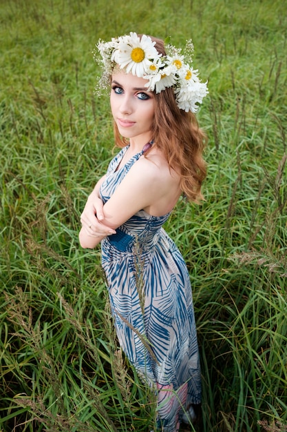 Retrato de joven mujer bonita con diadema de flores de manzanilla en la cabeza