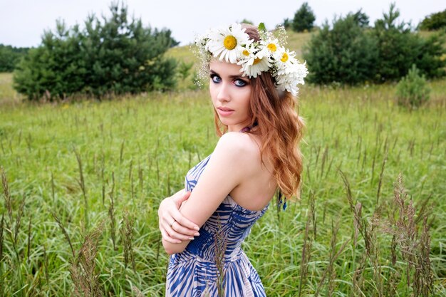 Retrato de joven mujer bonita con diadema de flores de manzanilla en la cabeza.