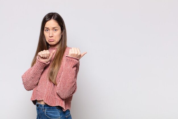 Retrato de una joven mujer bonita mostrando algo