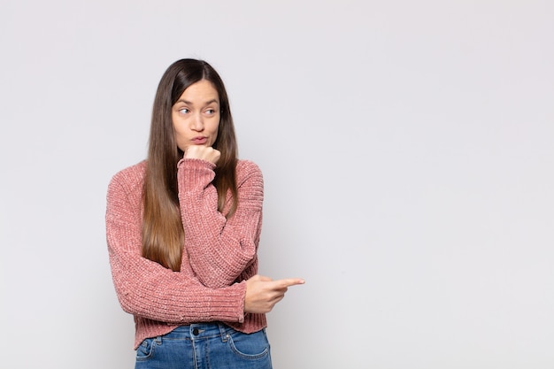 Foto retrato de una joven mujer bonita mostrando algo