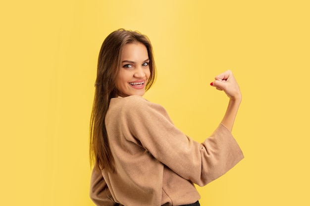 Retrato de joven mujer caucásica con emociones brillantes aisladas sobre fondo amarillo studio