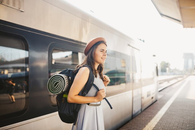 Retrato joven mujer caucásica con sonrisa toothy de pie en la estación de tren