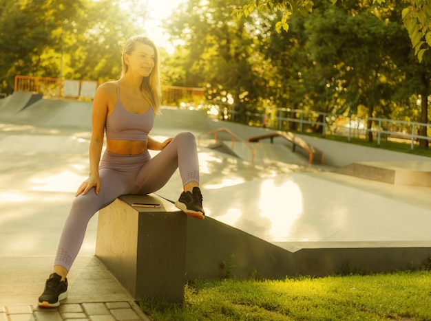 Retrato de una joven mujer deportiva en ropa deportiva al aire libre. Concepto de estilo de vida saludable. Entrenamiento de la mañana