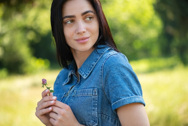 retrato, de, un, joven, mujer hermosa, con, un, flor, en, ella, manos, paseo, en el parque