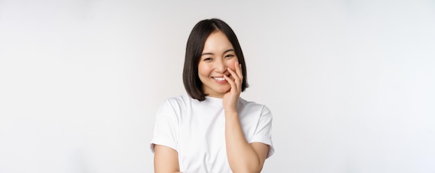 retrato, de, joven, mujer hermosa, niña coreana, reír, y, sonriente, mirar, coqueto, posición, contra, fondo blanco