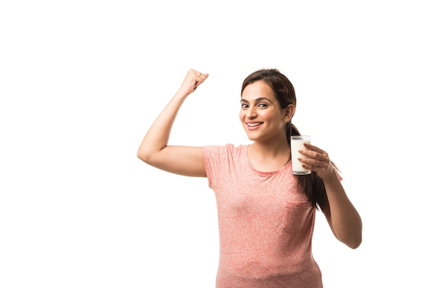 Retrato joven mujer india o asiática bebiendo leche del vaso aislado sobre fondo blanco.