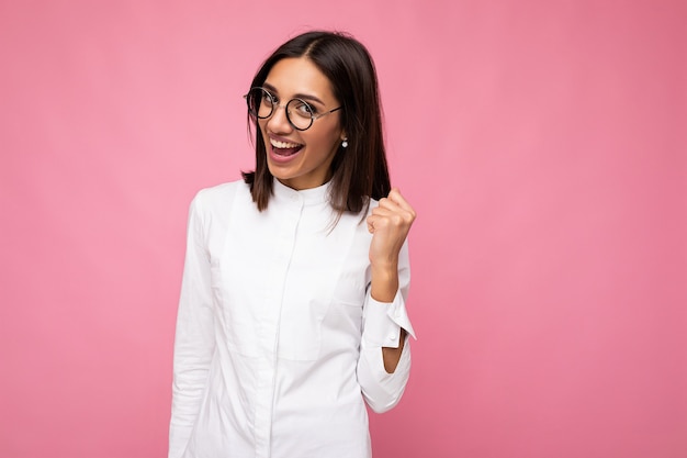 Retrato de joven mujer morena atractiva sonriente feliz positiva con sinceras emociones vistiendo