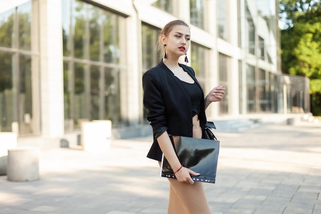 Foto retrato de una joven mujer de negocios con una carpeta en la ciudad