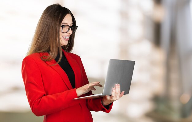 Retrato de una joven mujer de negocios usando laptop