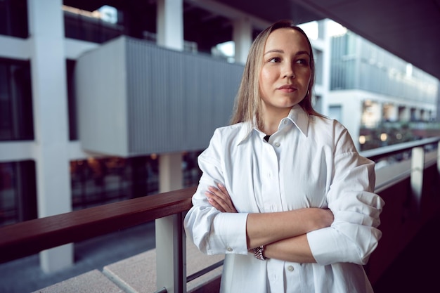 Retrato de una joven mujer de oficina parada en el balcón disfrutando de la vista de la ciudad