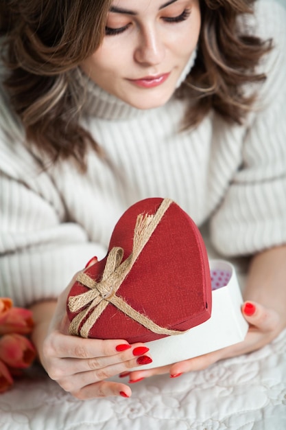 Retrato de joven mujer sonriente feliz mantenga caja de regalo roja