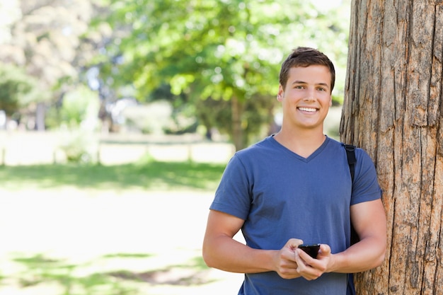 Foto retrato de un joven musculoso con un teléfono inteligente