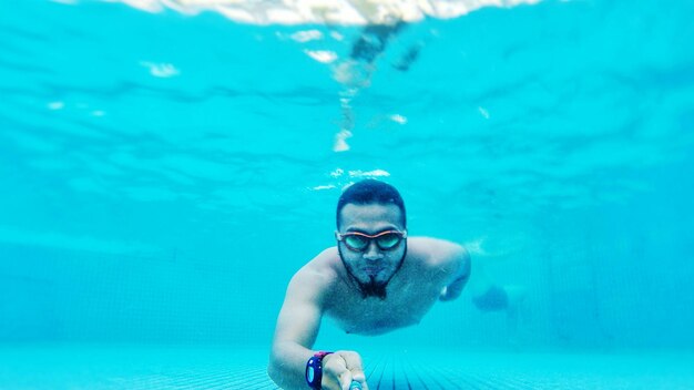 Retrato de un joven nadando en una piscina