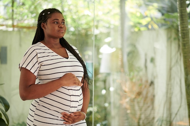 Retrato de una joven negra pensativa anticipando al bebé