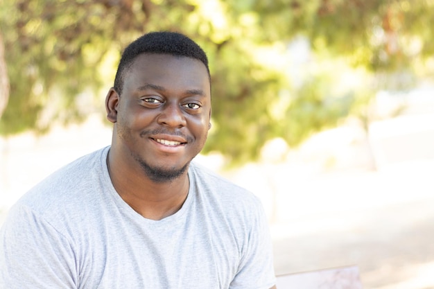 Retrato de un joven negro en un parque soleado