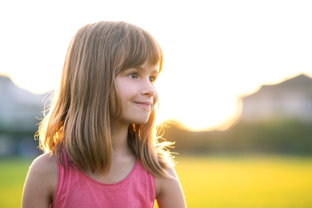 Retrato de joven niña feliz relajarse al aire libre en una cálida noche de verano.