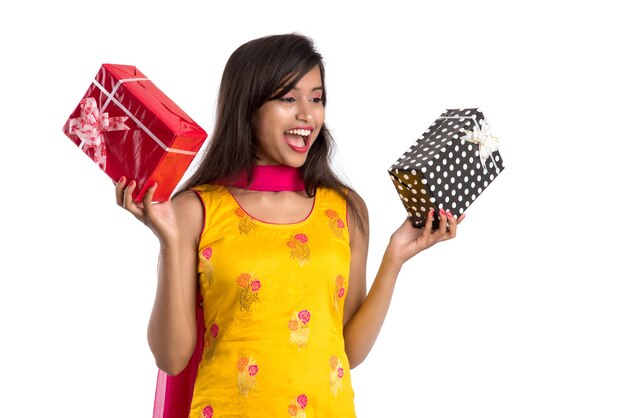 Retrato de joven niña india sonriente feliz sosteniendo cajas de regalo en blanco