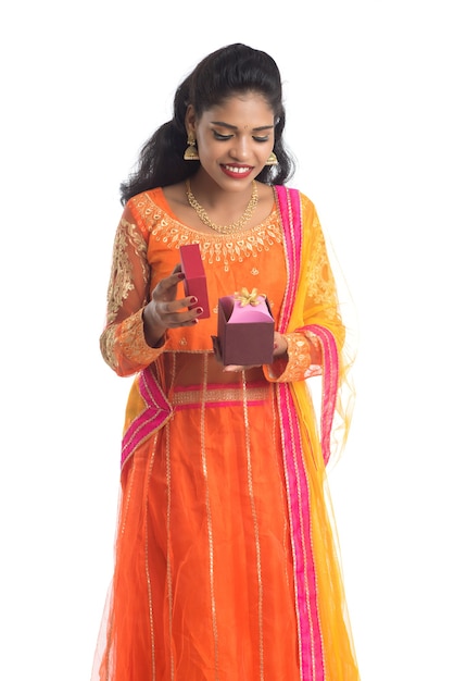 Retrato de joven niña india sonriente feliz sosteniendo cajas de regalo en blanco