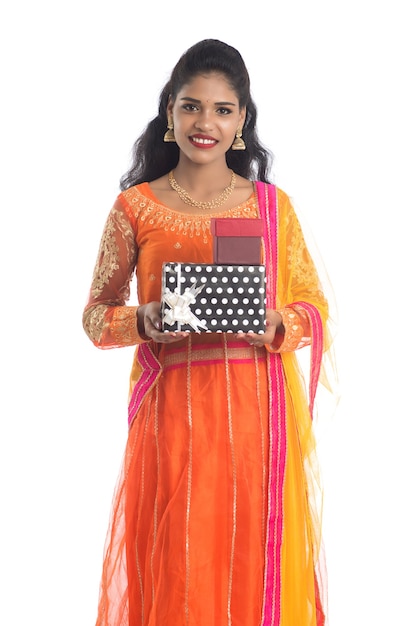 Retrato de joven niña india sonriente feliz sosteniendo cajas de regalo en blanco