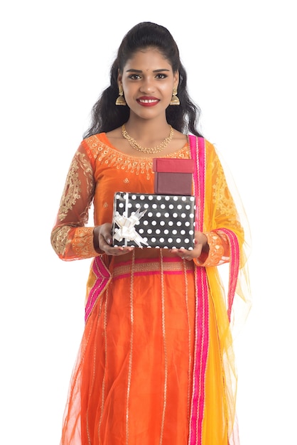 Retrato de joven niña india sonriente feliz sosteniendo cajas de regalo en blanco