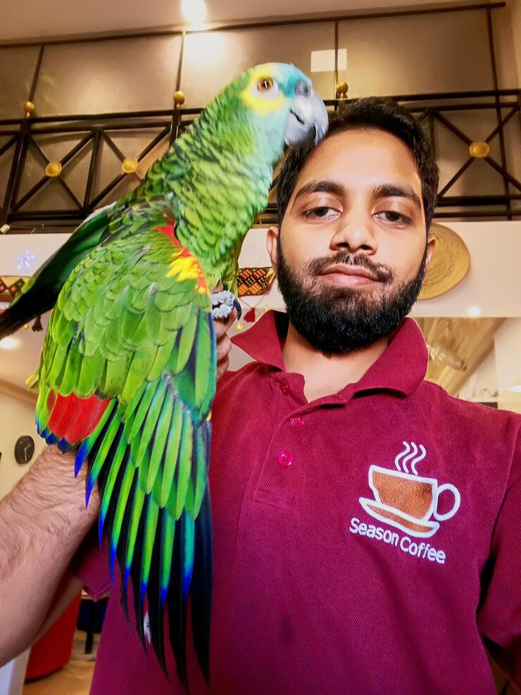 Foto retrato de un joven con un pájaro en casa